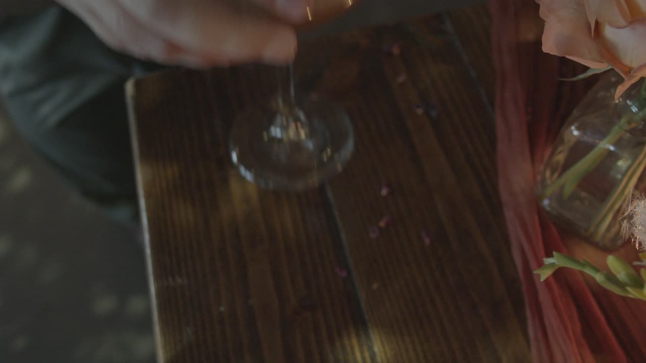 손이 프레임에 닿아 테이블에서 에스프레소 마티니를 집습니다.