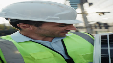 Construction worker holding solar panel
