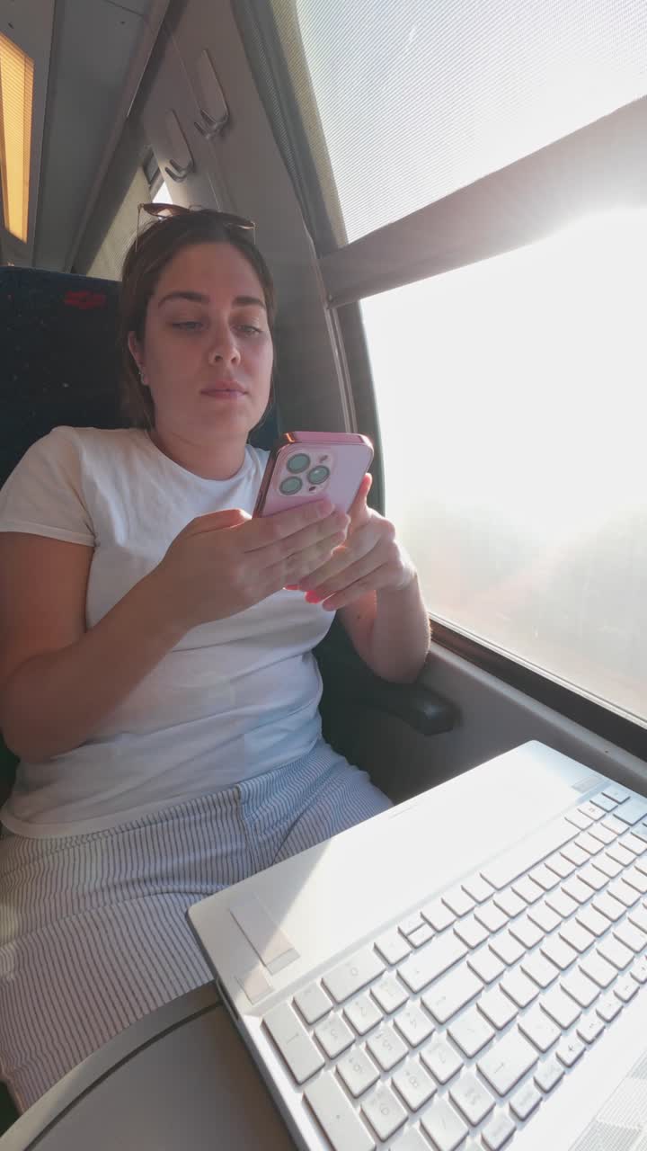 Young Professional Using Her Smartphone While Working on a Train