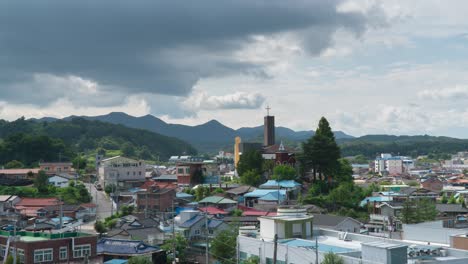 timelapse of clouds moving over residential houses with church at geumsan county, in south chungcheong province, south korea