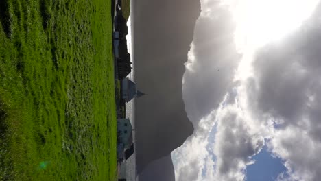sunlight emerges over vidareidi village reflecting in the fjord after the storm