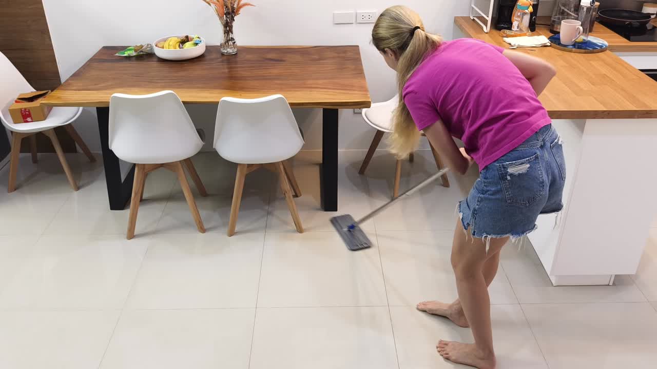 mujer limpiando el suelo de la cocina