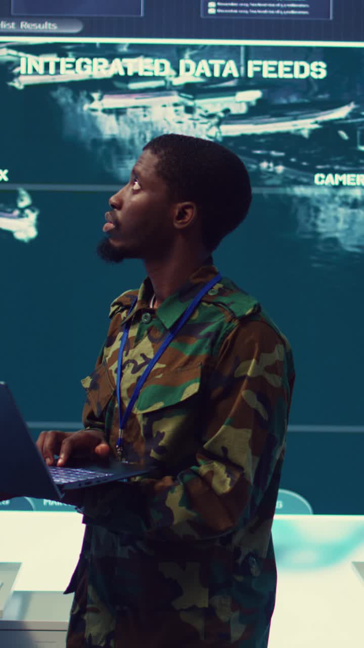 Military Man Monitoring Integrated Data Feeds in Control Room