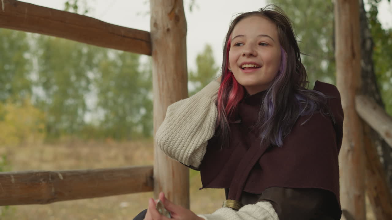 소녀 전사 는 패배 한 적 에게서 트로피 목걸이 를 들고 앉아 있다