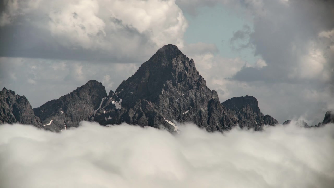 Il maestoso picco di una montagna che si erge sopra un mare di nuvole