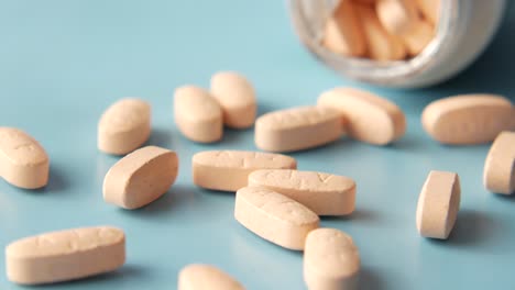 orange oval pills on a light blue surface