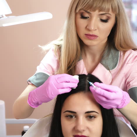 handsome woman receives an injection in the head. the concept of mesotherapy. thrust to strengthen the hair and their growth. work of the cosmetologist