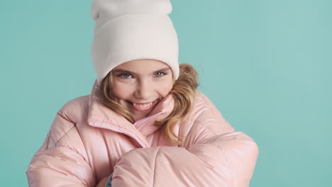 teenage caucasian girl with winter clothes feeling cold in front of the camera.