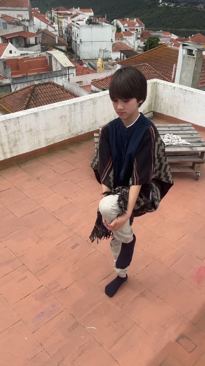 Bambino che pratica yoga su un tetto