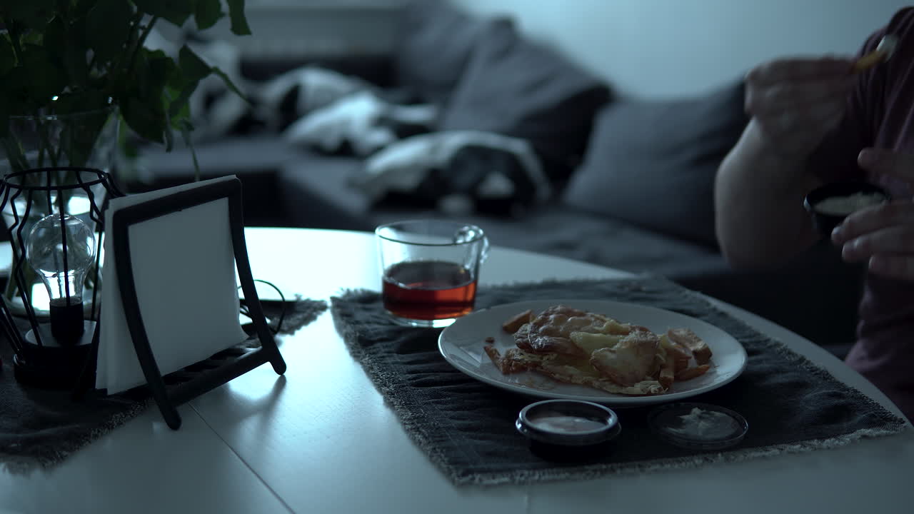 Take a glass of tea from the table and drink it, then eat white plate fries and soak in the sauce, close-up at the table