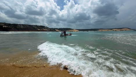 Dolly-Out-Aufnahme-Eines-Kleinen-Motorboots,-Das-An-Einem-Warmen-Sommertag-Vom-Ufer-Des-Cacimba-Strands-In-Der-Berühmten-Surfstrandstadt-Baia-Formosa-In-Rio-Grande-Do-Norte,-Brasilien,-Wegsegelt