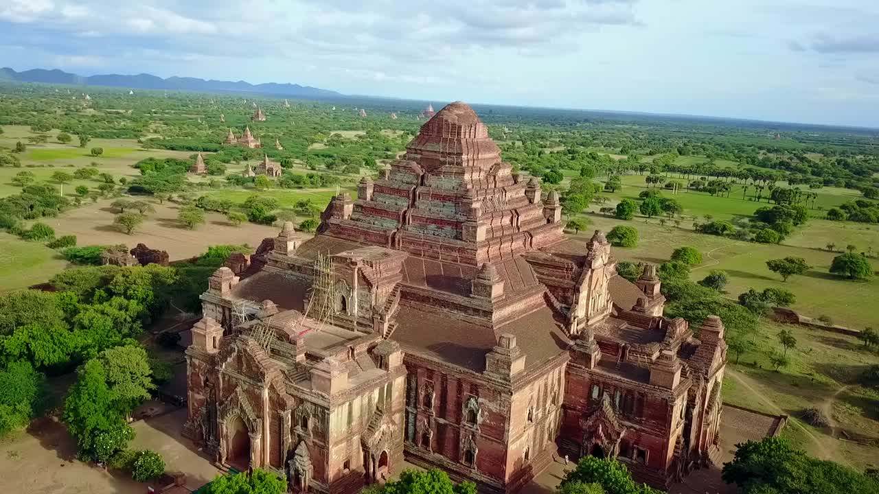 A smooth aerial point-of-interest shot circling the Narathu Temple in Bagan, Myanmar, highlighting its stunning architecture and historical significance in a serene setting.