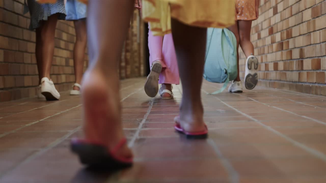 슬로우 모션으로 초등학교 복도에서  ⁇ 고 있는 학교 가방을 가진 다양한 여학생들