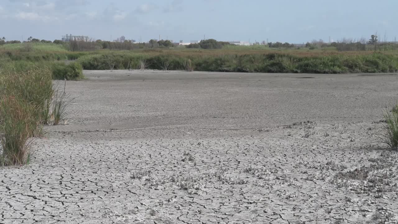 Cracked mud floor of a dried up lake bed showing the effects of drought and climate change