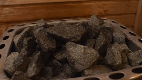 narrow focus closeup: water splashed onto hot granite sauna rocks