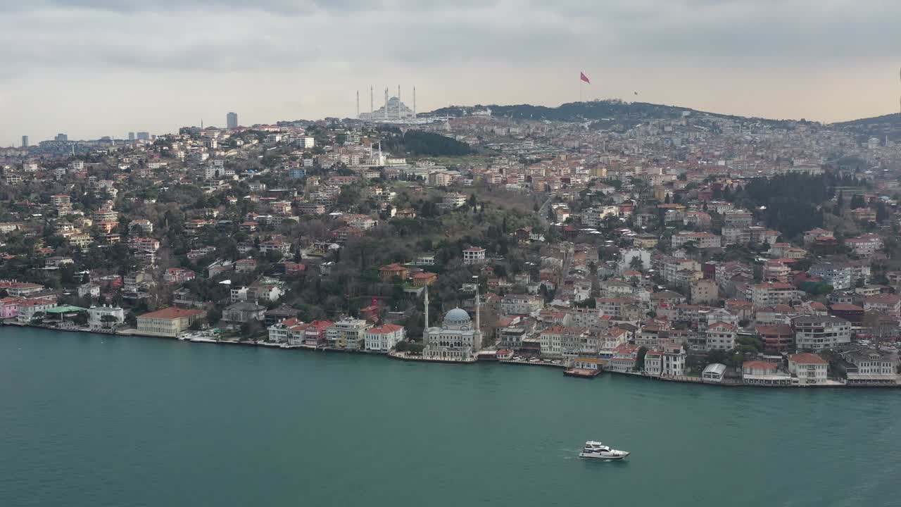 Yate navegando en el Bósforo, se ven una torre y una mezquita en otoño, dron