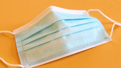 man's hand picking up a blue cotton face mask