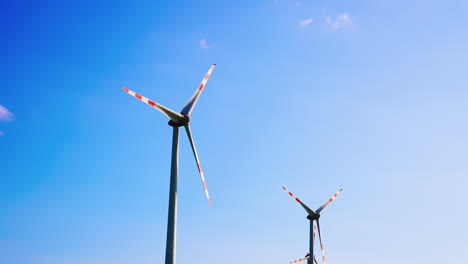 wind turbines create solar energy. tall wind turbines rotate against a clear blue sky, harnessing wind energy to produce clean electricity