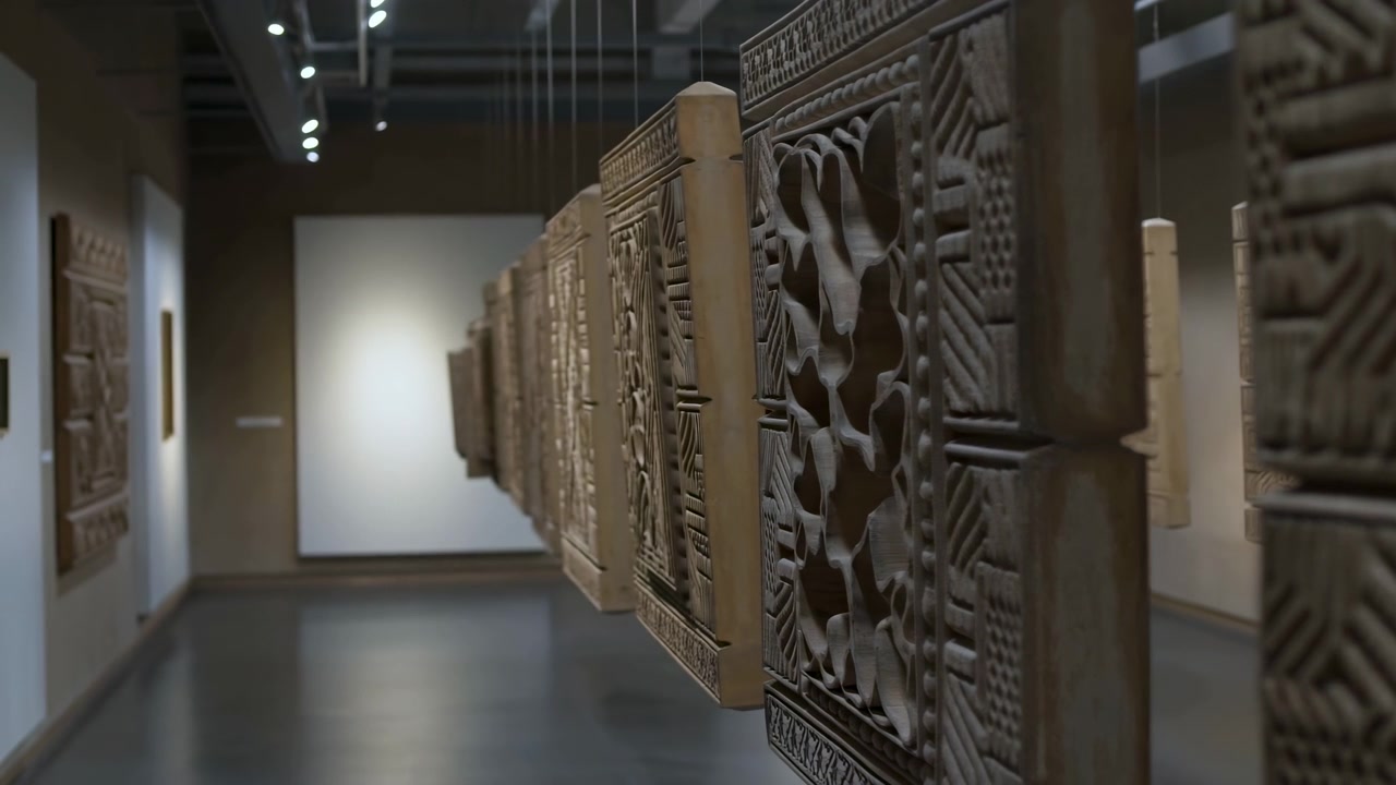 Un'inquadratura statica di un corridoio ornato, caratterizzato da boiserie in legno e luci a soffitto metalliche, ambientato in un ambiente interno neutro. Il design del corridoio evidenzia intricati pannelli a parete.