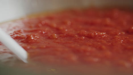 sliding shot of fresh tomato sauce in a pot ready to be used on a traditional italian pizza recipe