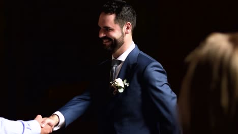 el novio se para en la puerta de la iglesia antes de casarse para saludar a los invitados a la boda