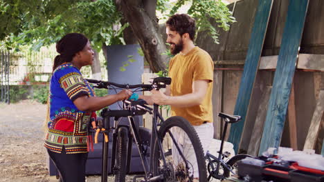 pareja que fija el marco de la bicicleta para la reparación