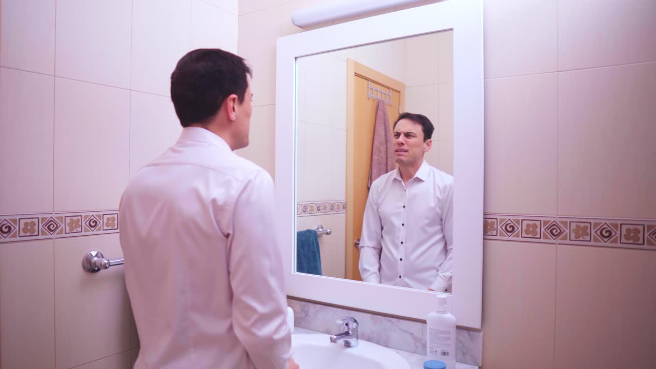 Businessman motivating himself in bathroom mirror