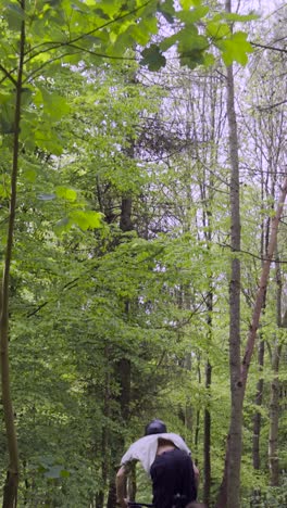 Vertikales-Video-Eines-Mannes-Auf-Einem-Mountainbike,-Der-Einen-Luftsprung-Auf-Einem-Feldweg-Durch-Wald-Macht-1