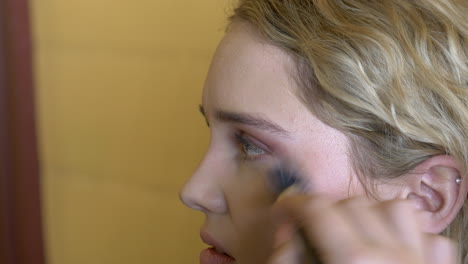 blush being applied to cheek on beautiful young teenager, close up