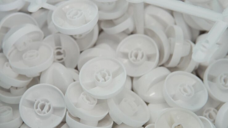 A large number of small white plastic parts in the factory