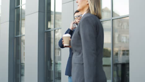 Hombre-De-Negocios-Con-Gafas-Hablando-Por-Teléfono-En-La-Calle