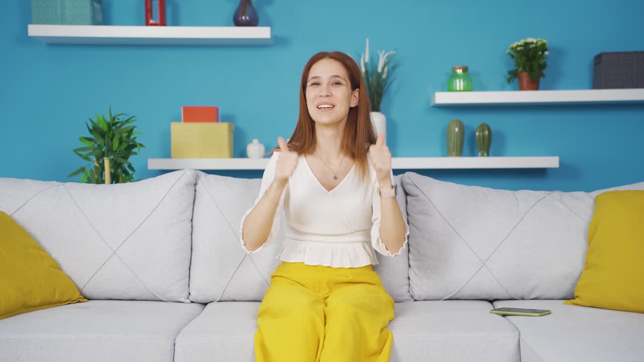 mujer joven dando saludo y aplausos a la cámara.