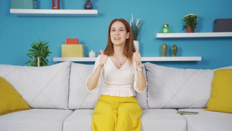 young woman giving greeting and applause to camera.