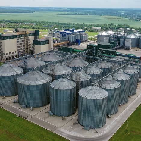 agriculture storage for harvest. grain elevators on green nature background. exterior of agricultural factory. aerial view.