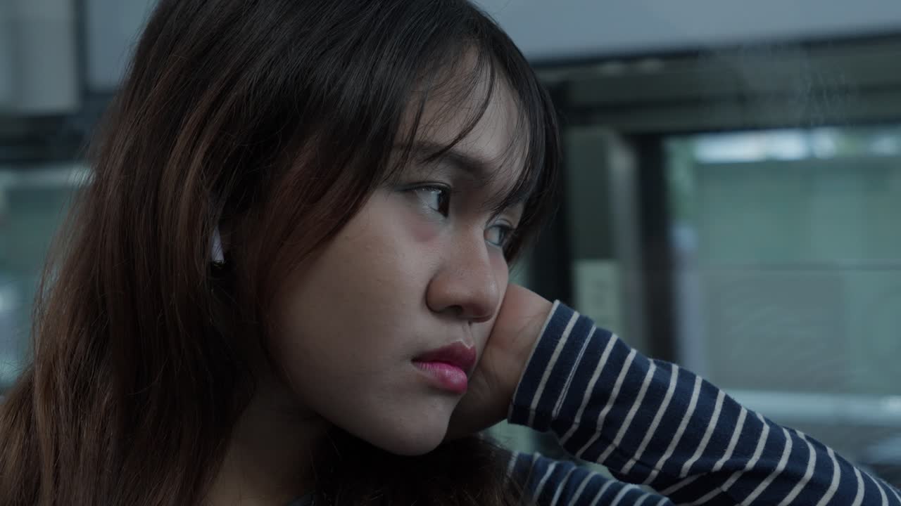 Pensive Young Woman Looking Out Window