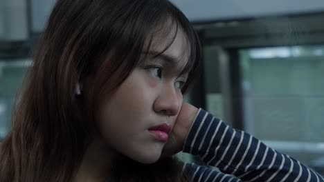 pensive young woman looking out window