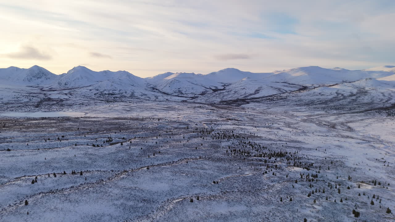 Breathtaking aerial view near Fish Lake in Whitehorse, Yukon, showcasing the vast Canadian wilderness. Snow-covered mountains and frozen waters highlight the sub-zero winter beauty.