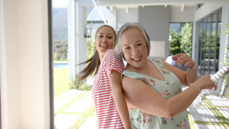 dancing together at home, asian grandmother and granddaughter enjoying time