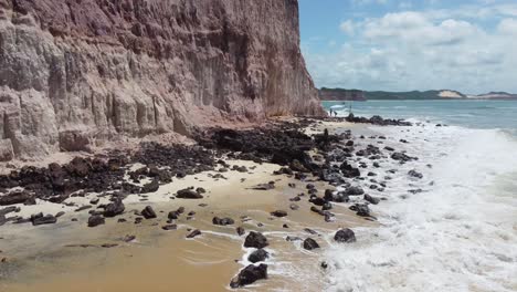 preservar el cartel en inglés y portugués en la colorida playa brasileña del acantilado en el desierto del noreste durante la marea alta