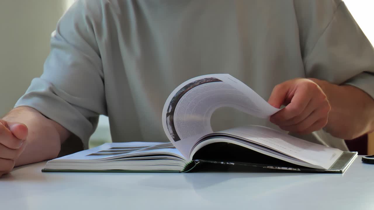 Man reading a book. Turning pages slowly