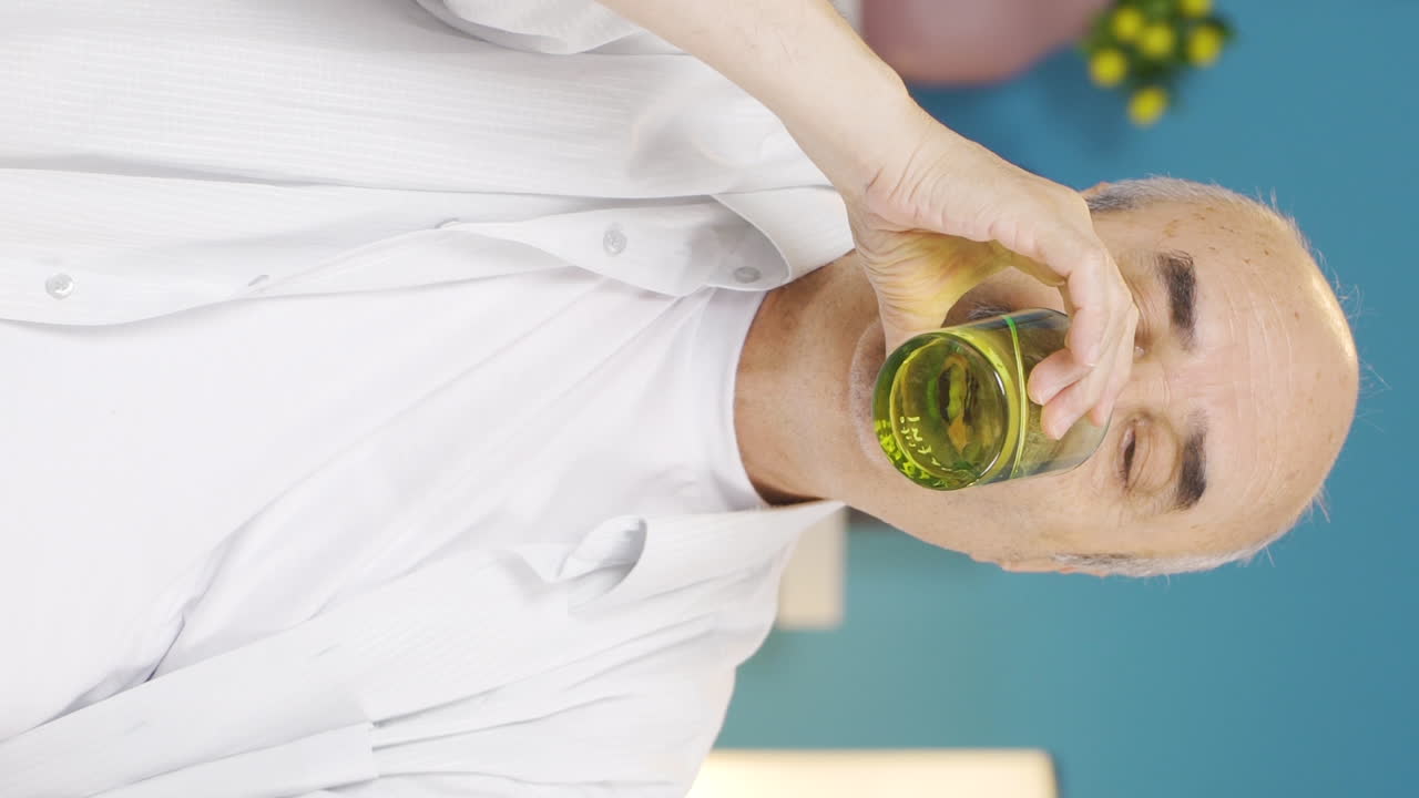 video vertical del anciano que consume agua.