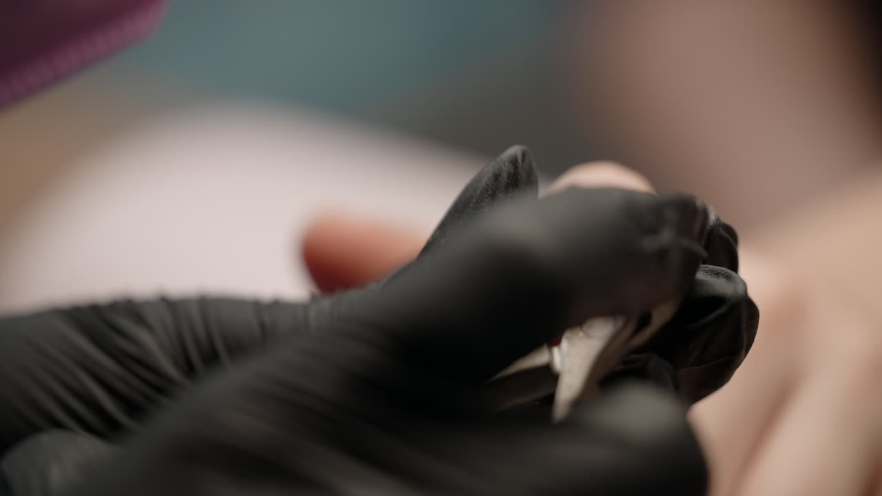Woman getting her nails trimmed at a nail salon.
