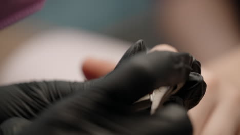 woman getting her nails trimmed at a nail salon.