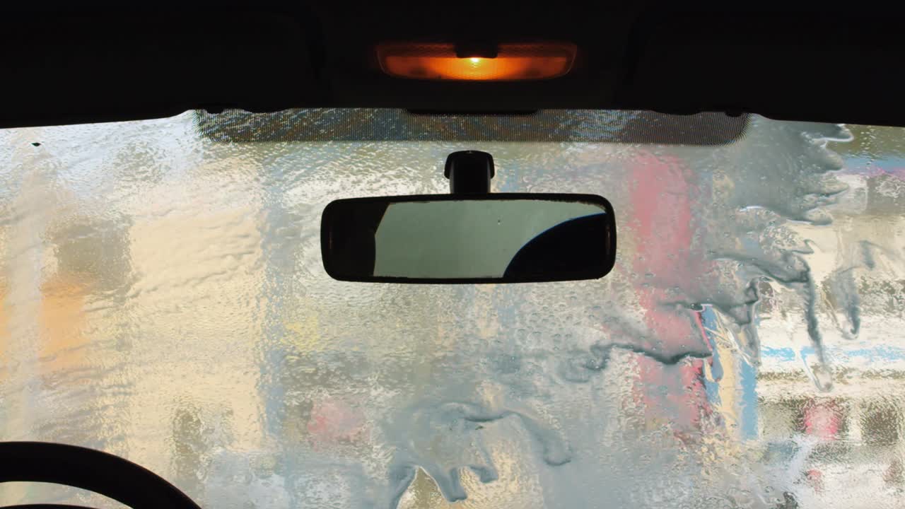 inside shot of a windshield being washed in slow motion
