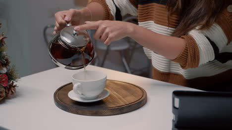 Close-up-of-kettle-and-cup-of-tea-on-kitchen-counter