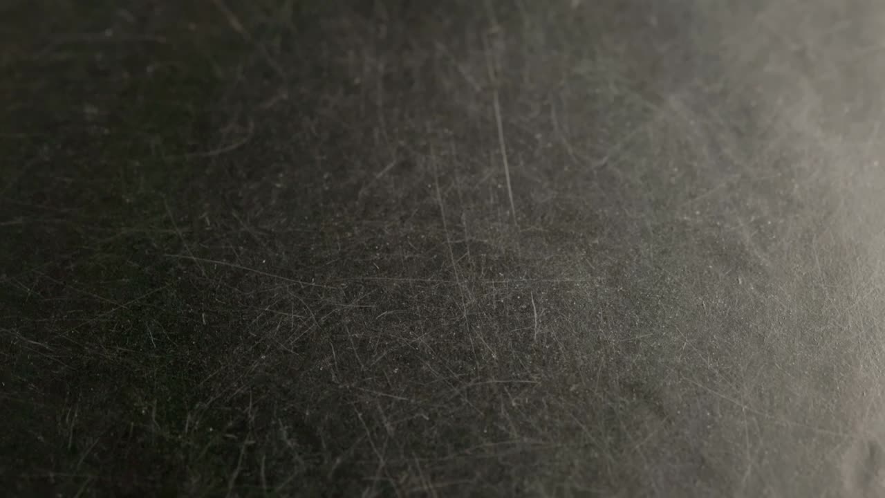 black scratched surface closeup rotating background with selective focus