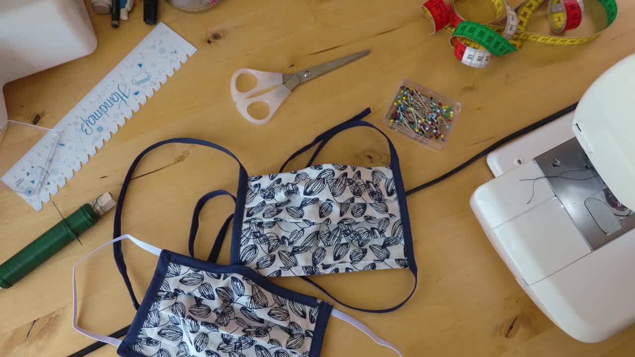 Homemade face masks for protection with sewing utensils, rotating shot.
