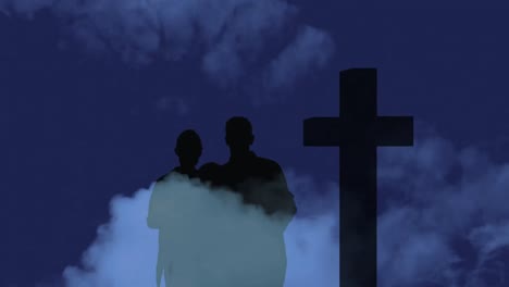 Animation-of-silhouette-of-Christian-cross-and-a-family-on-dark-background