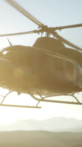 helicopter flying over desert landscape at sunset