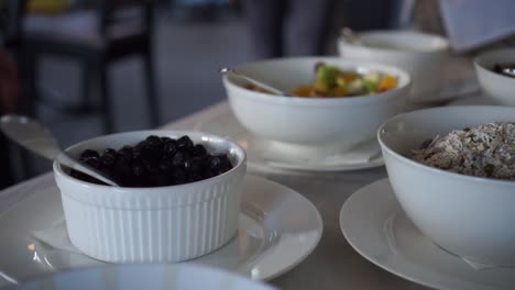 man and woman having homemade toasted museli, fruit salad, milk and orange juice from buffet style breakfast in a luxury boutique hotel